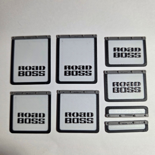 Six black and white scale model mudflaps with 'ROAD BOSS' branding, arranged on a white background with a black border and text overlay.
